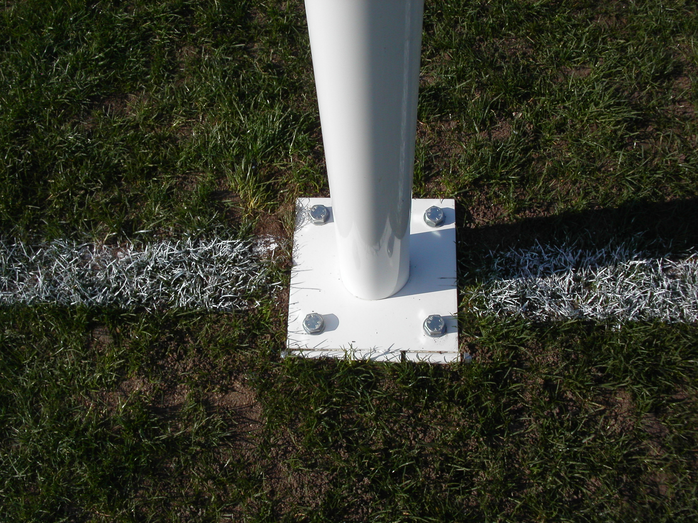 Articulation à la base d'un poteau de rugby pour rabattre le but au sol